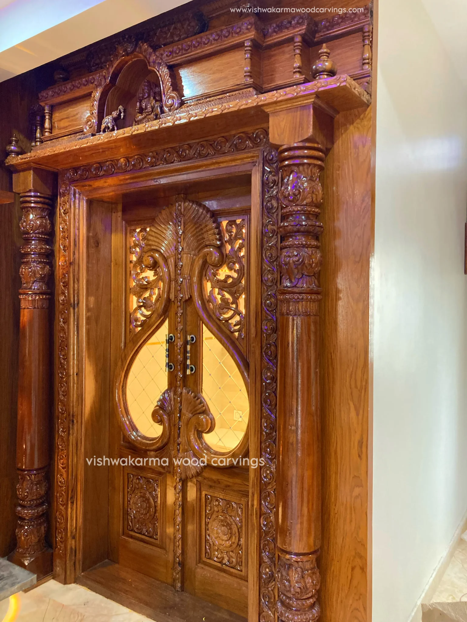 Traditional hand-carved wooden pooja room door design with pillars | Vishwakarma wood carvings | Temple-style teak wood door for home.