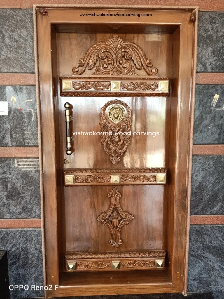 Hand-carved wooden main door with floral patterns and brass decorative elements